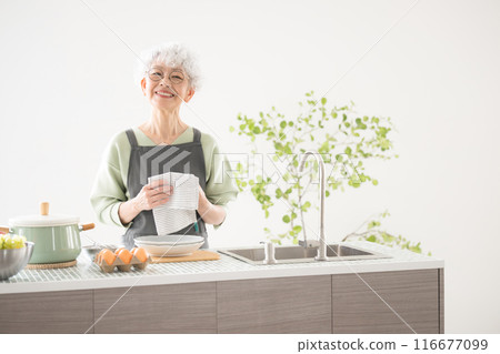 Senior woman doing housework and cooking, wiping dishes in island kitchen Senior woman doing housework and cooking, wiping dishes in island kitchen 116677099