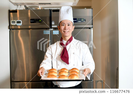 Smiling Asian man making bread in the kitchen Smiling Asian man making bread in the kitchen 116677476