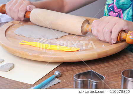 Teenage girl molds clay by using rolling pin at home. Hobbies and tools. Creativity for children, education.  116678800