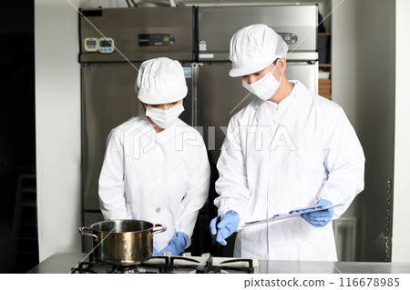 Asian male and female cooks checking work at a food factory Asian male and female cooks checking work at a food factory 116678985