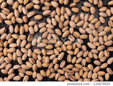 unpeeled pistachio on black background, top view unpeeled pistachio on black background, top view 116679005