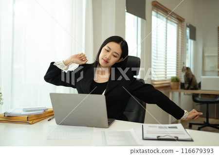 Young businesswoman stretching body at desk. Health and wellness in the workplace concept 116679393