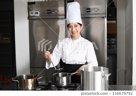 Young asian female chef cooking in the kitchen Young asian female chef cooking in the kitchen 116679792