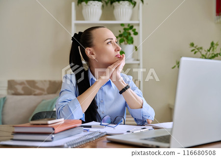Tired businesswoman having problems sitting at desk with laptop Tired businesswoman having problems sitting at desk with laptop 116680508