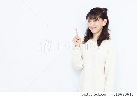 A woman who raises her index finger with a smile A woman who raises her index finger with a smile 116680615