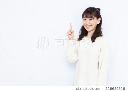 A woman who raises her index finger with a smile A woman who raises her index finger with a smile 116680616