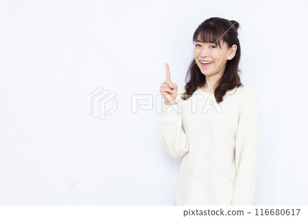 A woman who raises her index finger with a smile A woman who raises her index finger with a smile 116680617
