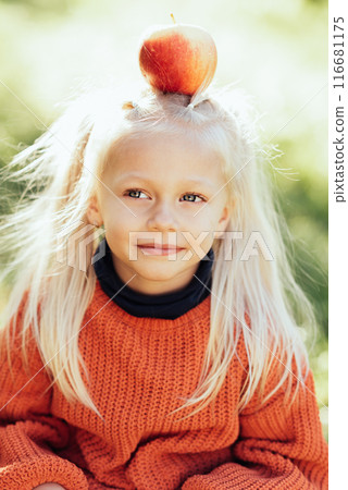 Child picking apples on farm in autumn. Little girl playing in tree orchard. Healthy nutrition. Cute little girl eating red delicious fruit. Harvest Concept. Apple picking. 116681175