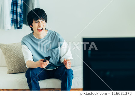 Young man watching TV Young man watching TV 116681373