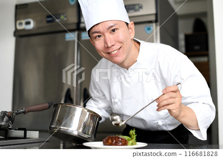 Young asian male chef serving food on a plate Young asian male chef serving food on a plate 116681828