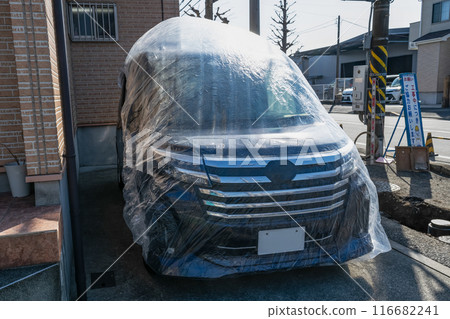 A car covered with a plastic bag for construction work A car covered with a plastic bag for construction work 116682241