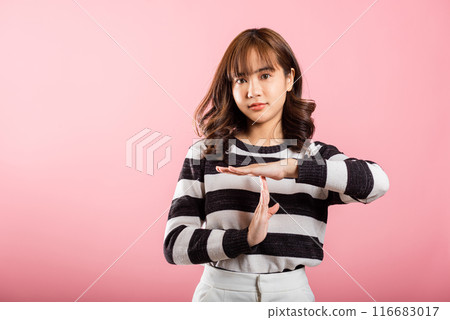 Closeup portrait young woman smiling making time out gesture with hands studio shot isolated on pink background, demonstrates break hand sign, stop time with copy space 116683017