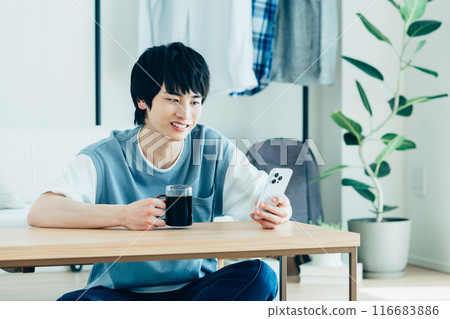 年輕人在客廳看智慧型手機 116683886