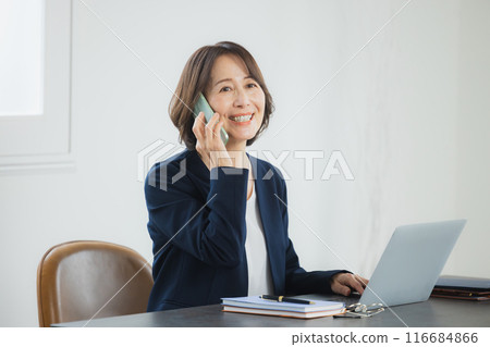 Middle-aged business woman working on a laptop 116684866