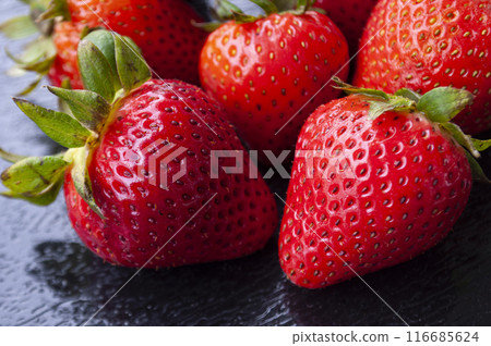 Close up of strawberries on black cover background. Healthy food and fruits concept. 116685624