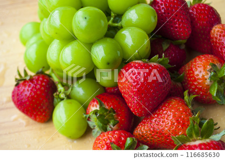 Mixture of strawberries and shining muscat on wooden table background. Suitable for fruits promotion. Mixture of strawberries and shining muscat on wooden table background. Suitable for fruits promotion. 116685630