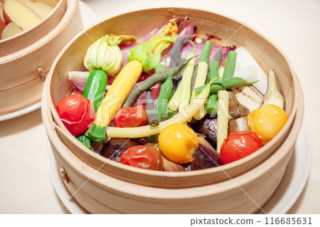 Colorful organic summer vegetables steamed in a bamboo steamer 116685631