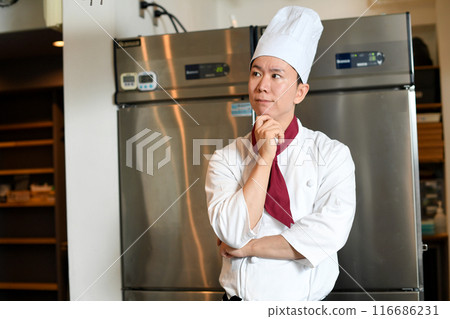 年輕的亞洲男廚師在廚房裡思考 116686231