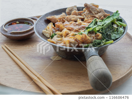Thai stir-fried Wide Rice Noodles in Sweet Soy Sauce with Pork and Chinese kale ( Pad See-Ew ). 116686476