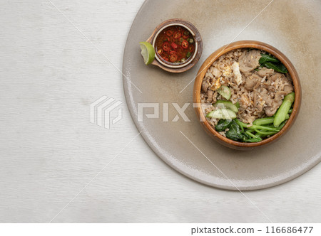 Egg fried rice with Onion, Fried pork, Chinese kale and Cucumber in Wooden bowl. 116686477
