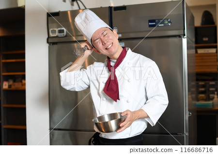 A troubled male pastry chef working in the kitchen 116686716