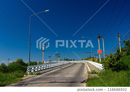 Road bridge against blue sky surrounding by tropical forest Road bridge against blue sky surrounding by tropical forest 116686932