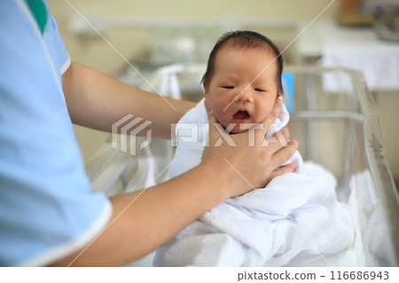 Nurse help Asian newborn infant belch after feeding milk in hospital 116686943