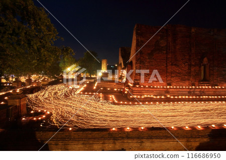 Buddhist people walk with light candles at wat Maheyong, Ayutthaya Buddhist people walk with light candles at wat Maheyong, Ayutthaya 116686950