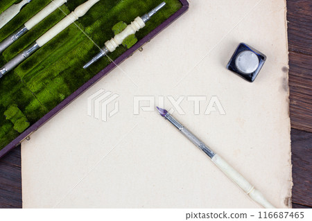 Vintage pen and inkwell on paper background 116687465