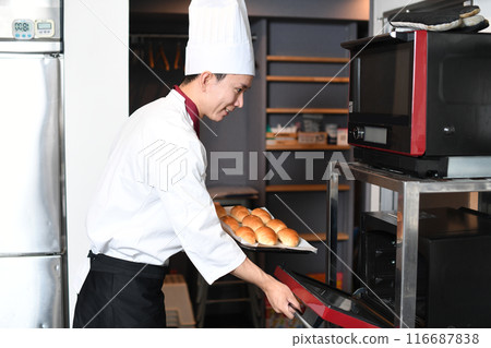 年輕人在廚房的烤箱裡做麵包 116687838