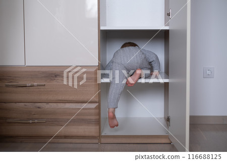 happy girl playing hide and seek in wardrobe happy girl playing hide and seek in wardrobe 116688125