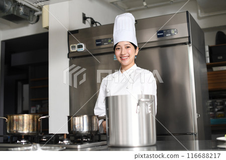 Young asian female chef cooking in the kitchen Young asian female chef cooking in the kitchen 116688217