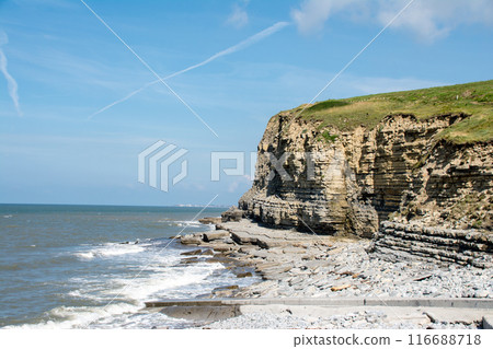 Steep cliffs and rocky coastline with exposed geological formations on the coastline, in the suburbs of South Wales Steep cliffs and rocky coastline with exposed geological formations on the coastline, in the suburbs of South Wales 116688718