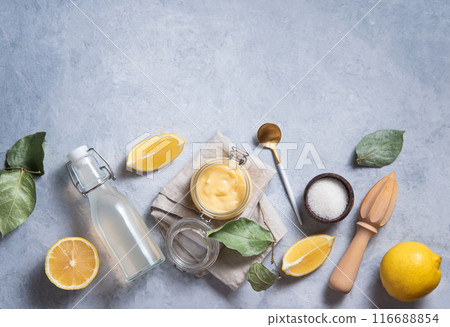 Breakfast flat lay concept. Delicious homemade lemon curd in a glass jar with lemon slices Breakfast flat lay concept. Delicious homemade lemon curd in a glass jar with lemon slices 116688854