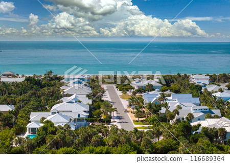 Expensive waterfront houses between green palm trees in Boca Grande, small town on Gasparilla Island in southwest Florida. Premium housing development in the USA Expensive waterfront houses between green palm trees in Boca Grande, small town on Gasparilla Island in southwest Florida. Premium housing development in the USA 116689364