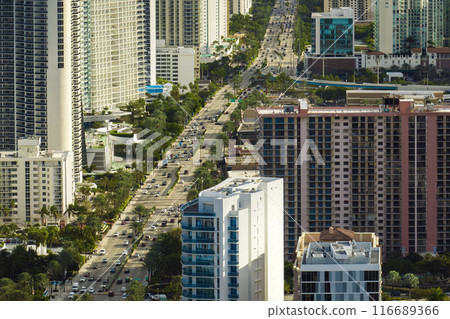 Expensive highrise hotels and condos on Atlantic ocean shore in Sunny Isles Beach city and busy street traffic. American tourism infrastructure in southern Florida 116689366