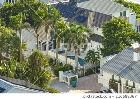 Expensive american residential house with rooftop covered with solar photovoltaic panels for producing of clean ecological electrical energy in suburban rural area. Concept of autonomous home Expensive american residential house with rooftop covered with solar photovoltaic panels for producing of clean ecological electrical energy in suburban rural area. Concept of autonomous home 116689367