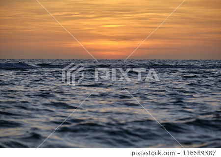 Dramatic red ocean waves at sunset with soft evening sea dark water Dramatic red ocean waves at sunset with soft evening sea dark water 116689387