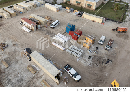 Construction site with building equipment on prepared ground in American suburbs. Aerial view of large development area of residential housing. Real estate market in the USA Construction site with building equipment on prepared ground in American suburbs. Aerial view of large development area of residential housing. Real estate market in the USA 116689431