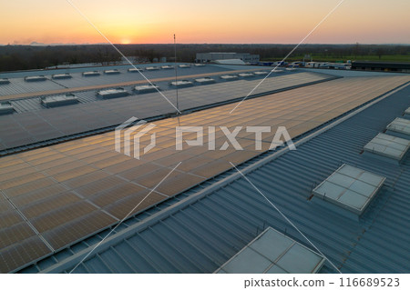 Blue photovoltaic solar panels mounted on building roof for producing clean ecological electricity at sunset. Production of renewable energy concept 116689523