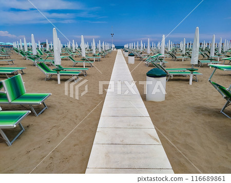 Summer. The sunbeds and parasols on the empty beach 116689861