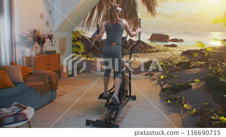 Female athlete in AR headset exercising on orbitrek. VR screen with landscape Female athlete in AR headset exercising on orbitrek. VR screen with landscape 116690715