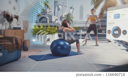 Sportswoman in AR headset exercises with fitball. VR screen shows virtual trainer and fitness app Sportswoman in AR headset exercises with fitball. VR screen shows virtual trainer and fitness app 116690718