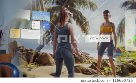 Athletic woman in AR headset starts online training. Virtual coach and interface of fitness app Athletic woman in AR headset starts online training. Virtual coach and interface of fitness app 116690726