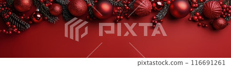 Festive Red Christmas Ornament and Pine Branch Garland on Red Background 116691261