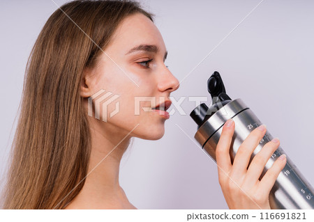 Closeup side view of sportive female after training who drinking fresh water from sport bottle Closeup side view of sportive female after training who drinking fresh water from sport bottle 116691821