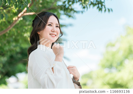 一位女商人在街上的一棵樹下打拳 一位女商人在街上的一棵樹下打拳 116693136