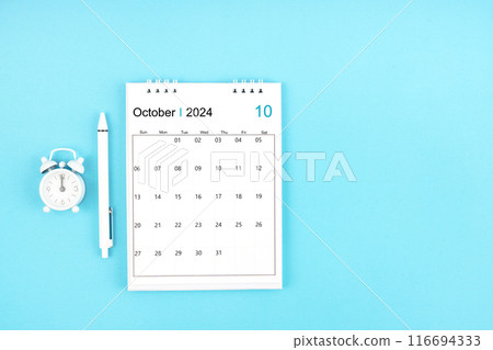 October 2024, Monthly desk calendar for 2024 year and pen with alarm clock on blue background. 116694333