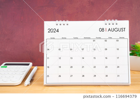 August 2024 white calendar and calculator with pen on table. 116694379