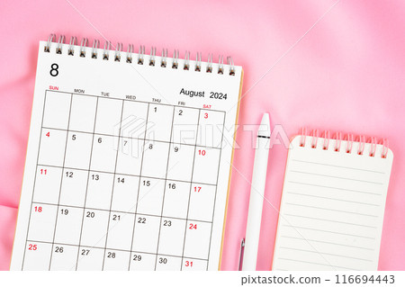 August 2024 month calendar and pen with open diary on pink fabric background. 116694443